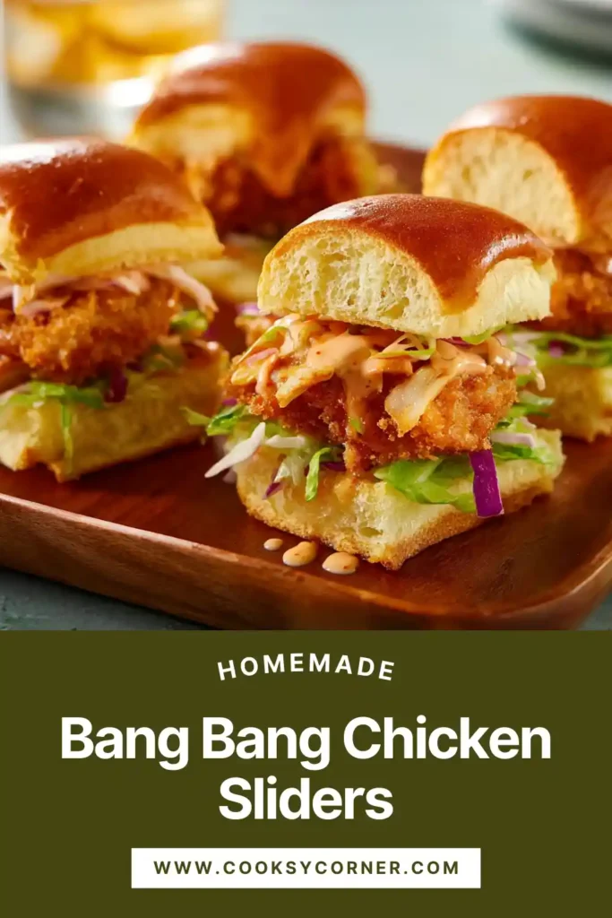 Close-up of crispy bang bang chicken sliders drizzled with creamy sauce and layered with fresh lettuce.