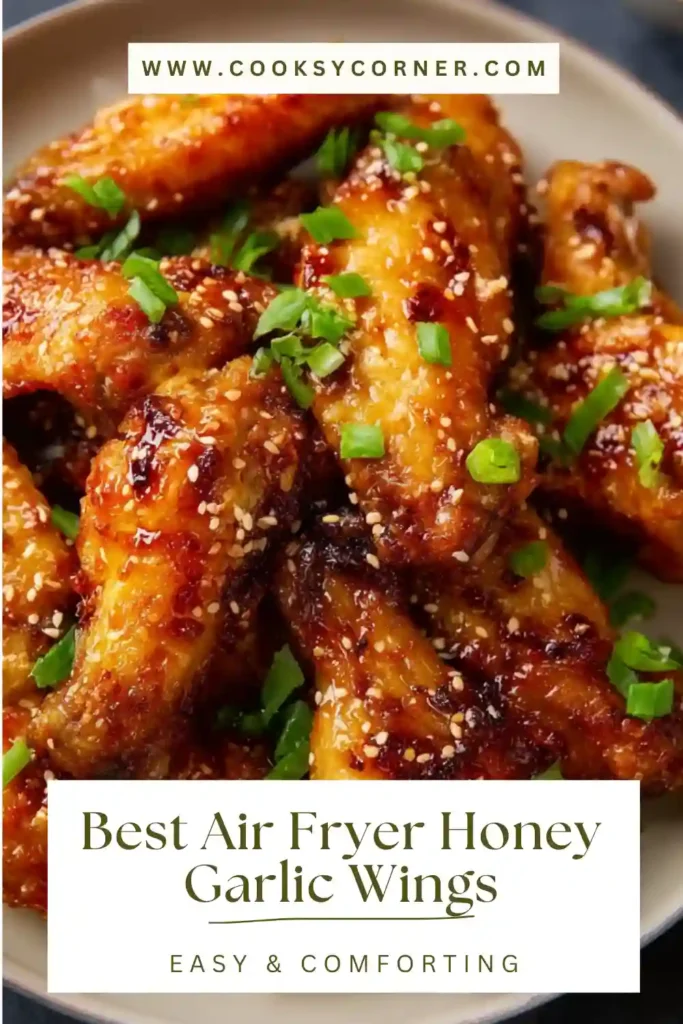 Air fryer honey garlic wings coated in sticky sauce and garnished with green onions.