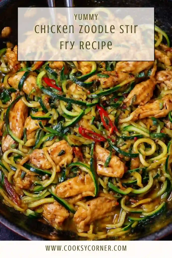 Chicken zoodle stir fry served in a skillet with sesame seeds and green onions, showing tender chicken and glossy zucchini noodles.