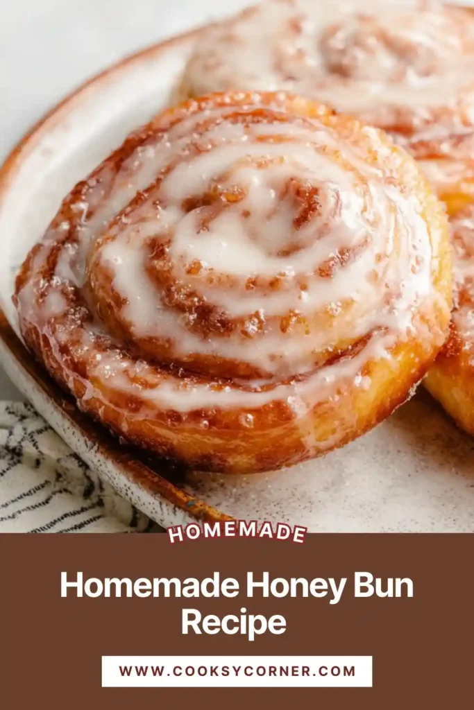 Golden fried honey buns stacked on a plate with honey glaze dripping over the edges.