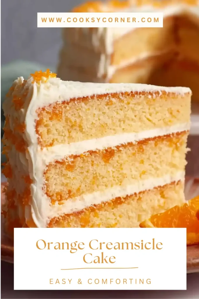A slice of orange creamsicle cake showing soft orange vanilla layers with creamy orange frosting, served on a dessert plate. The cake looks moist and rich with citrus flavor.