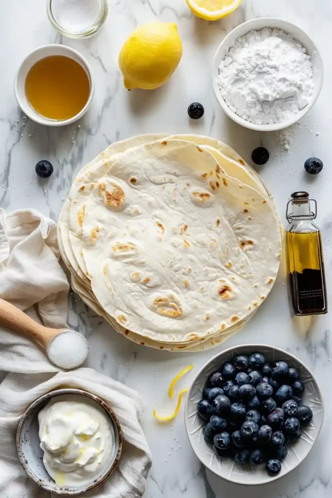 Blueberry cream cheese chimichangas served warm with powdered sugar and lemon zest garnish.