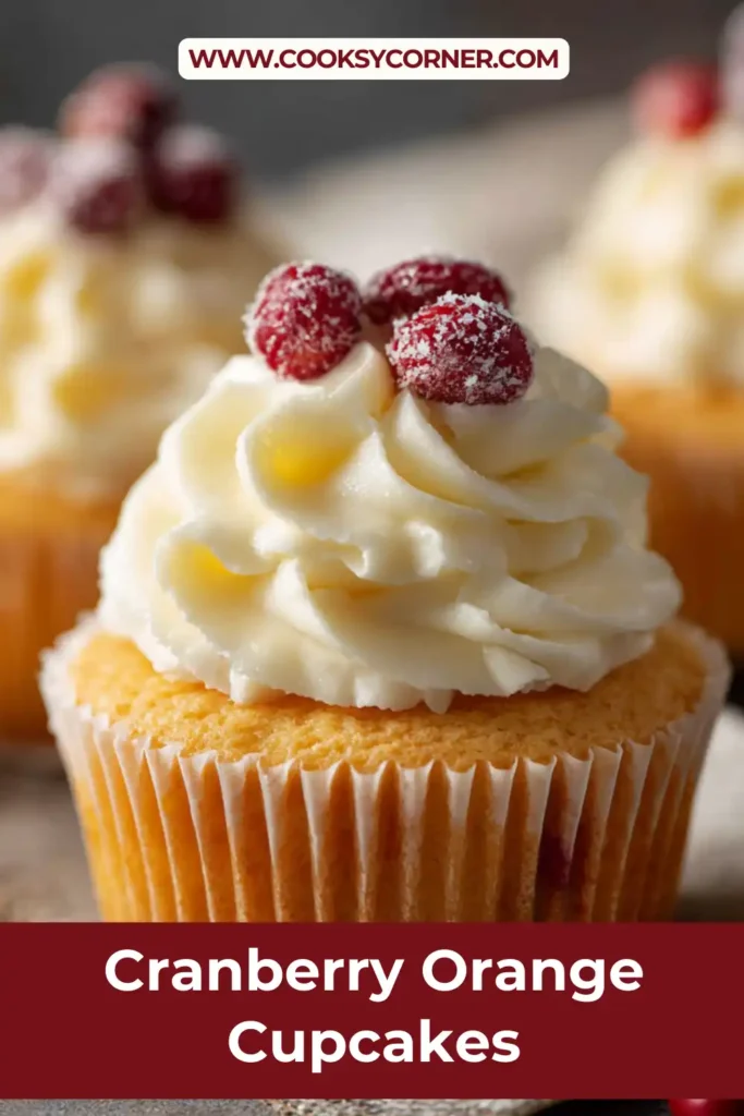 Close-up of citrus cupcake with visible cranberry pieces and creamy frosting.