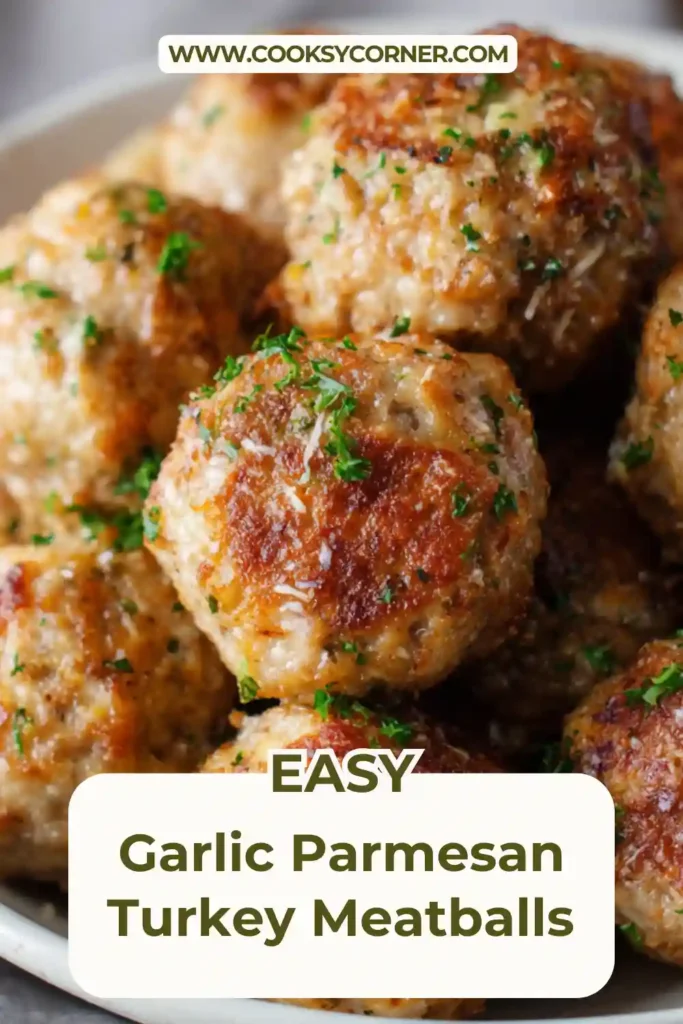 Close-up of Garlic Parmesan Turkey Meatballs served over spaghetti with marinara sauce. The tender turkey meatballs are topped with grated parmesan and fresh herbs.