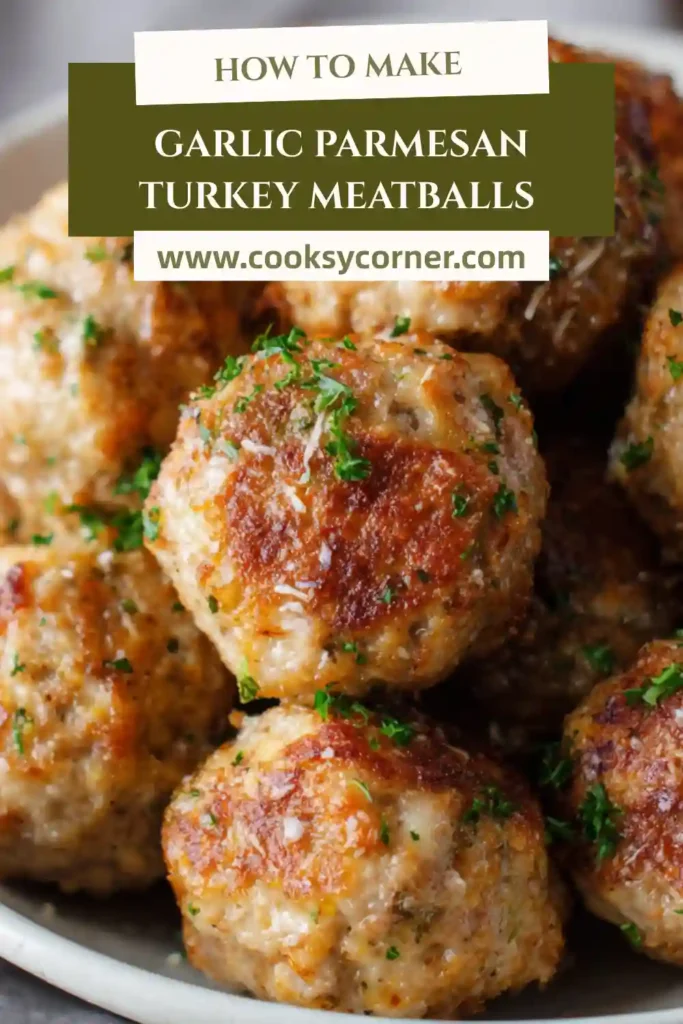 Garlic Parmesan Turkey Meatballs arranged on a white serving platter with dipping sauce. These oven-baked turkey meatballs look moist and flavorful.