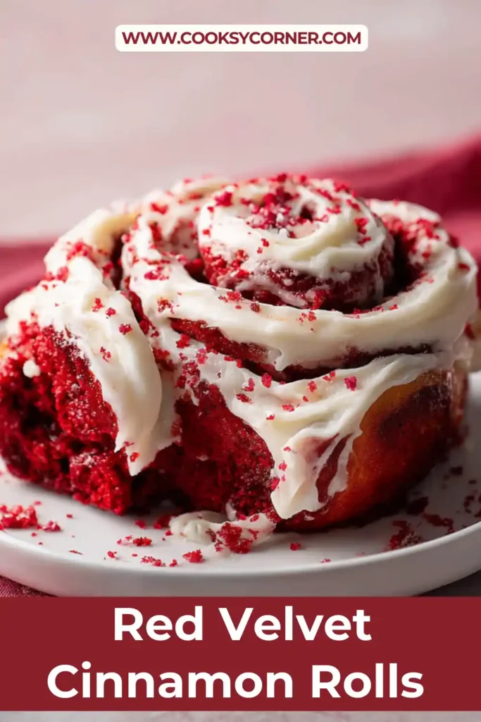 Close-up of homemade red velvet cinnamon rolls showing fluffy texture and thick cream cheese frosting. The cocoa cinnamon filling creates deep red swirls.
