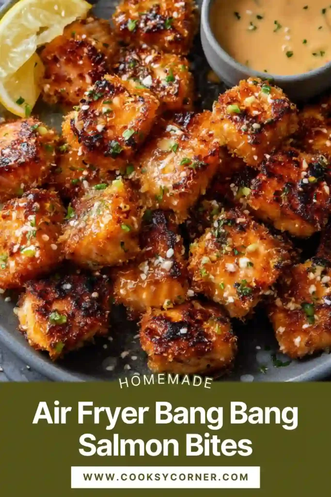 Crispy Air Fryer Bang Bang Salmon Bites drizzled with creamy sweet chili sauce and garnished with fresh chives on a white plate.