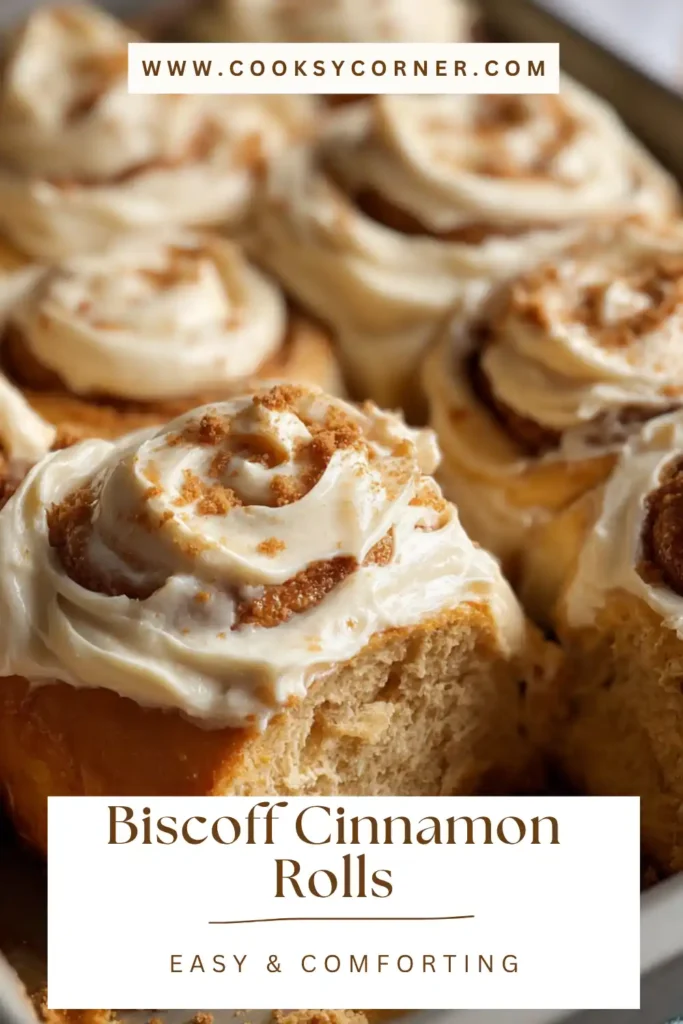 Close-up of fluffy cinnamon rolls topped with Biscoff frosting and crushed cookies.