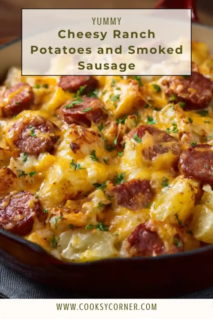 A skillet filled with cheesy ranch potatoes and smoked sausage topped with fresh parsley and melted cheddar cheese. The golden potatoes and sausage create a hearty comfort dinner.