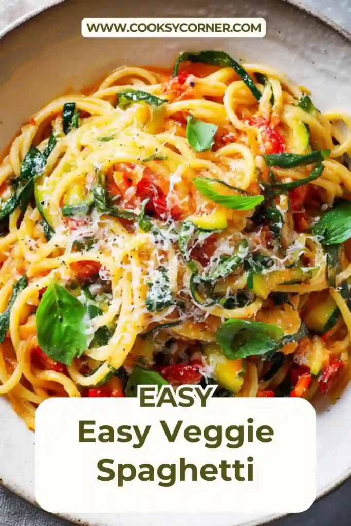 A bowl of easy veggie spaghetti topped with roasted red peppers, spinach, and fresh basil. The pasta is coated in a rich vegetable tomato sauce.