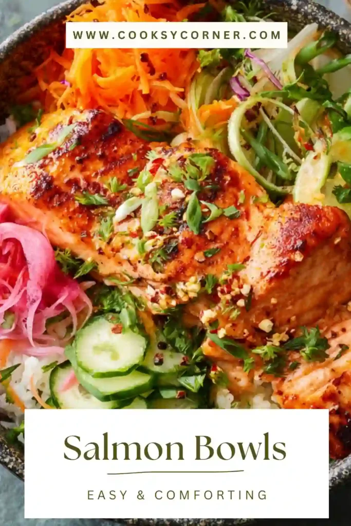 A colorful salmon bowl with crispy air fryer salmon, fresh vegetables, and cauliflower rice topped with sesame seeds and herbs.