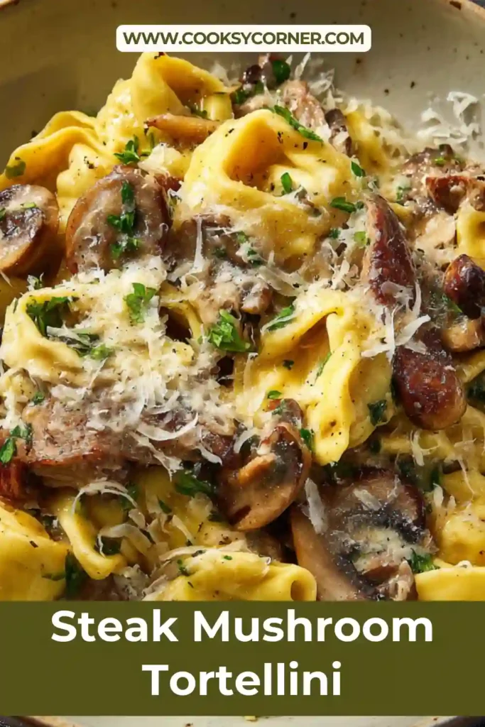A bowl of steak mushroom tortellini topped with shaved Parmesan and fresh basil in a creamy sauce. Tender steak slices and mushrooms are mixed with soft cheese tortellini.