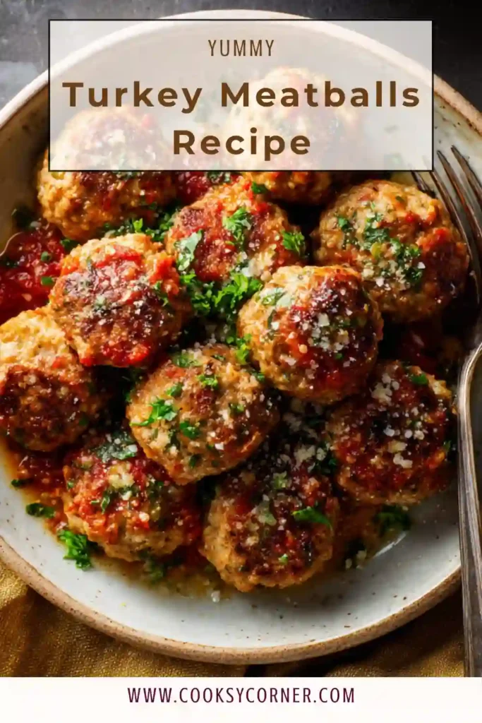Juicy baked turkey meatballs arranged in a skillet with tomato sauce and fresh parsley. A healthy and flavorful turkey meatballs recipe.