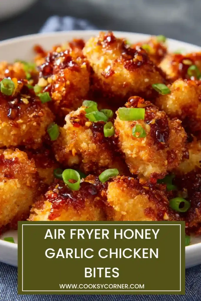 Air fryer chicken bites with sesame seeds and green onions, coated in sticky honey garlic sauce.