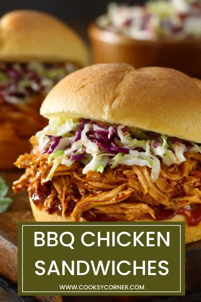 Homemade BBQ chicken sandwich with saucy pulled chicken and crunchy pickle topping on a bun.