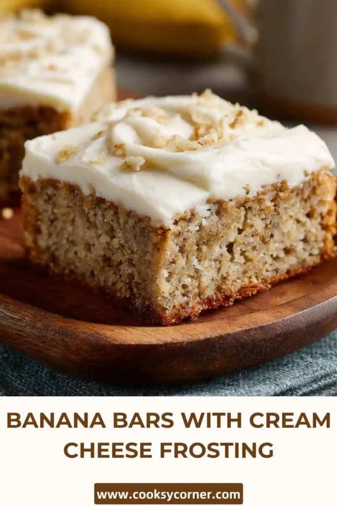 Soft banana cake bars topped with thick cream cheese frosting on a tray.