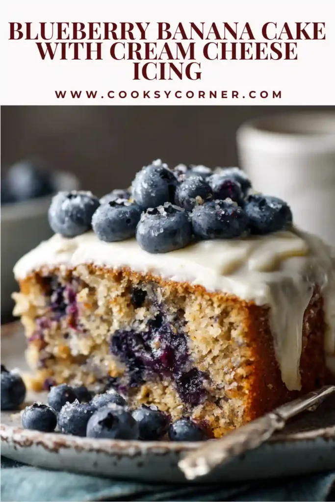 A moist blueberry banana cake topped with creamy cream cheese icing and fresh blueberries on top. The texture looks soft and rich.