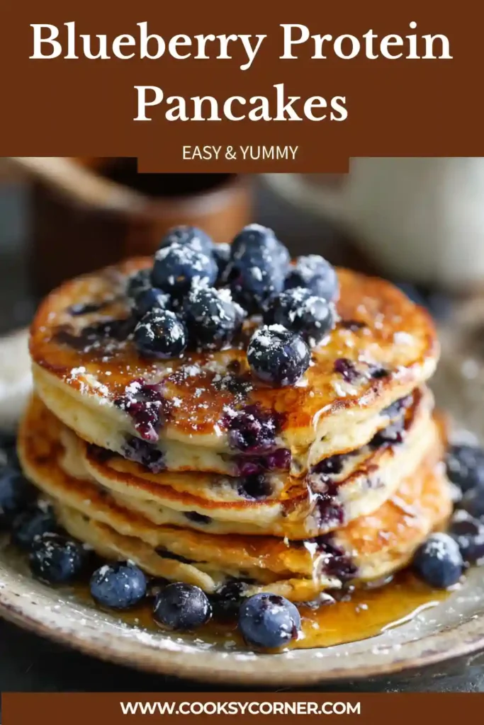 Stack of blueberry protein pancakes topped with fresh blueberries and syrup on a plate.