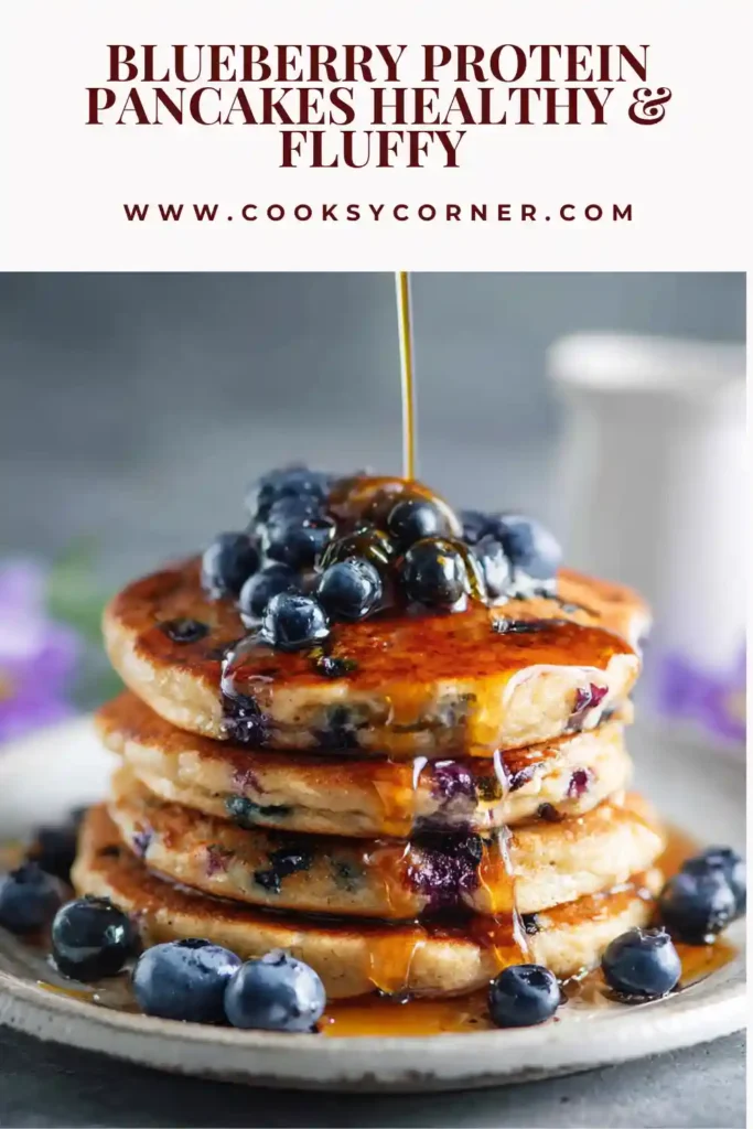Blueberry protein pancakes stacked with fresh blueberries and syrup on top.