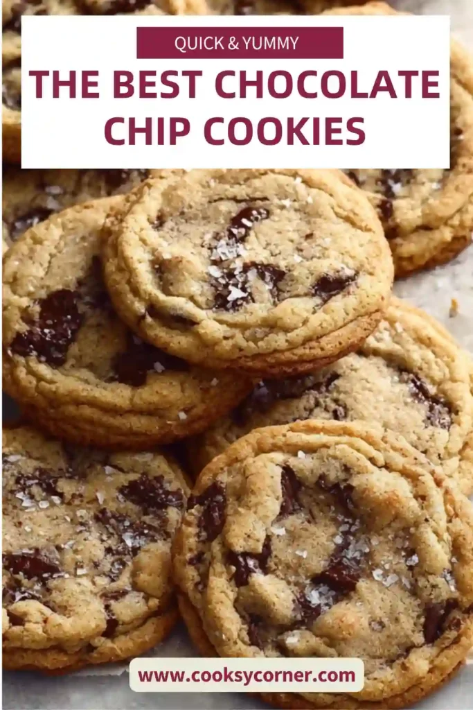 Freshly baked chocolate chip cookies with golden edges and melted chocolate chips on a baking tray. Soft centers and crisp edges visible.