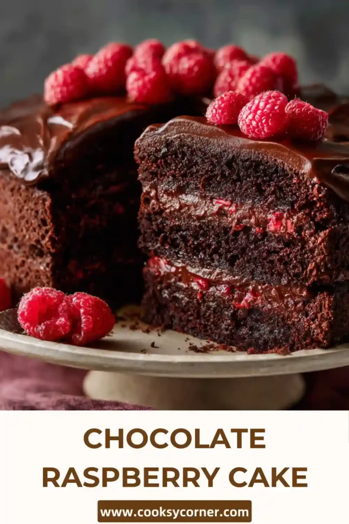 Slice of chocolate cake with raspberry filling and buttercream layers.