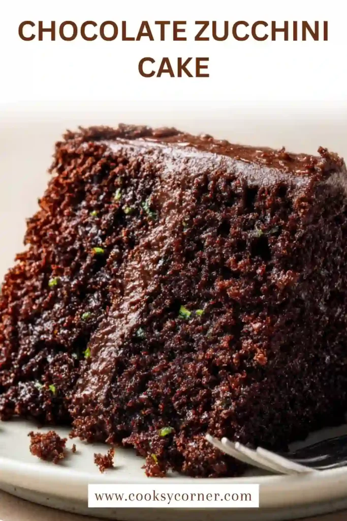 Chocolate zucchini cake with rich frosting and chocolate chips on top.