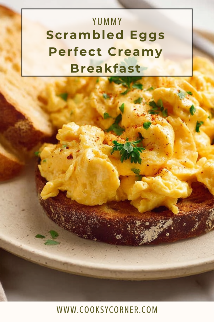 Creamy scrambled eggs served on buttered toast with soft fluffy curds and black pepper on top.