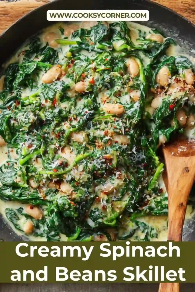 A skillet filled with creamy spinach and beans in a rich cheese sauce, served hot with crusty bread on the side.