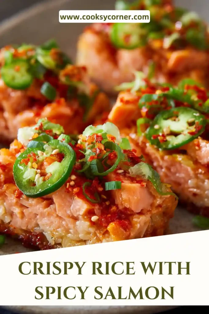 Close-up of crunchy rice squares with creamy salmon topping and sesame seeds.