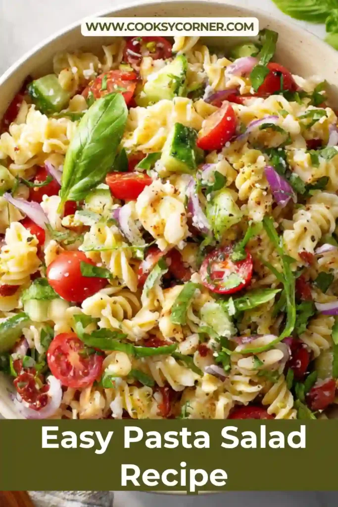 Healthy pasta salad with vegetables and feta served in a white bowl.