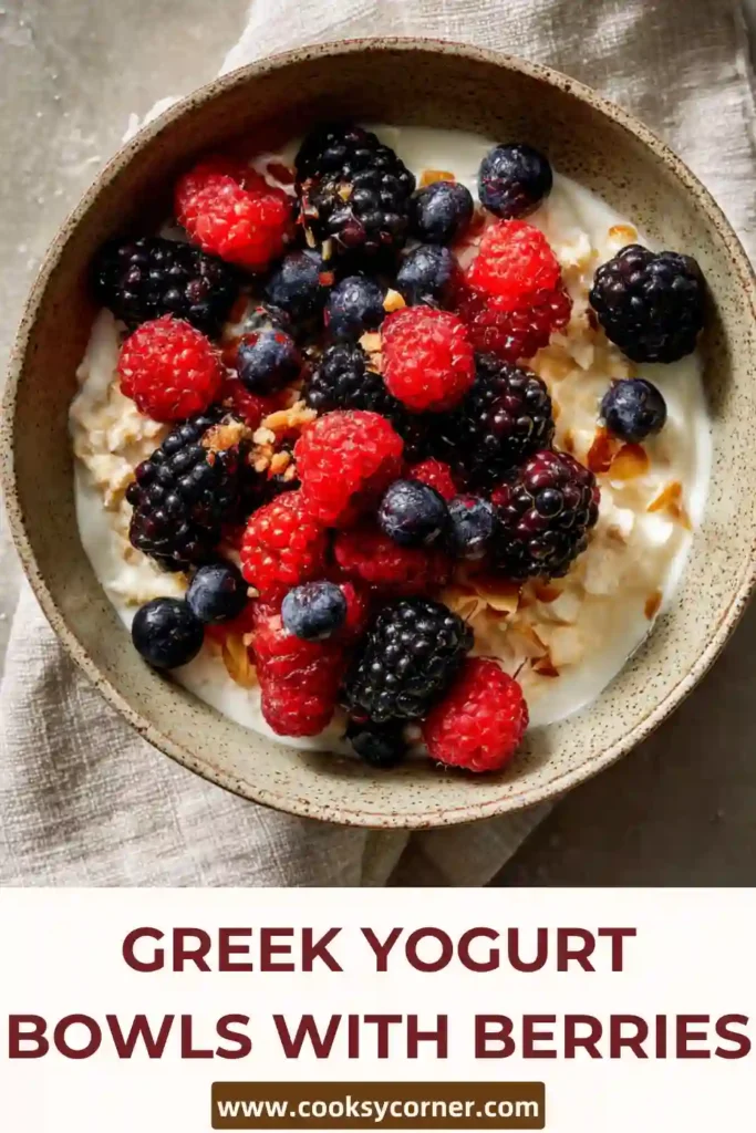 Healthy yogurt bowl with blueberries, raspberries, and crunchy granola, drizzled with honey.