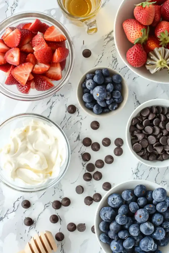 Greek yogurt chocolate berry bark with strawberries, blueberries, and chocolate chips frozen on a tray.