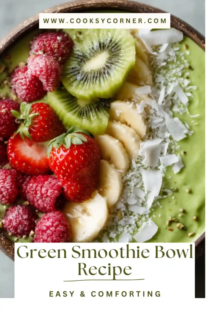 Healthy green smoothie bowl made with spinach, banana, and mango, decorated with fresh fruit and coconut topping.