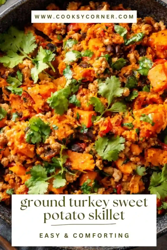 A skillet filled with ground turkey sweet potato skillet topped with melted cheese and fresh cilantro. The dish looks hearty and colorful with black beans and spices.