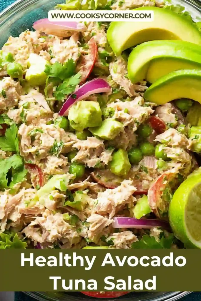 A bowl of creamy avocado tuna salad mixed with fresh cilantro, red onion, and lime juice. The texture looks smooth with chunks of tuna throughout.
