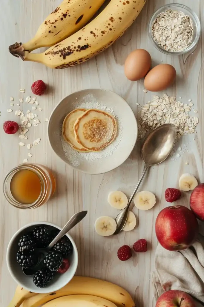 Stack of oat pancakes made with bananas and eggs, topped with fruit and drizzled with maple syrup.