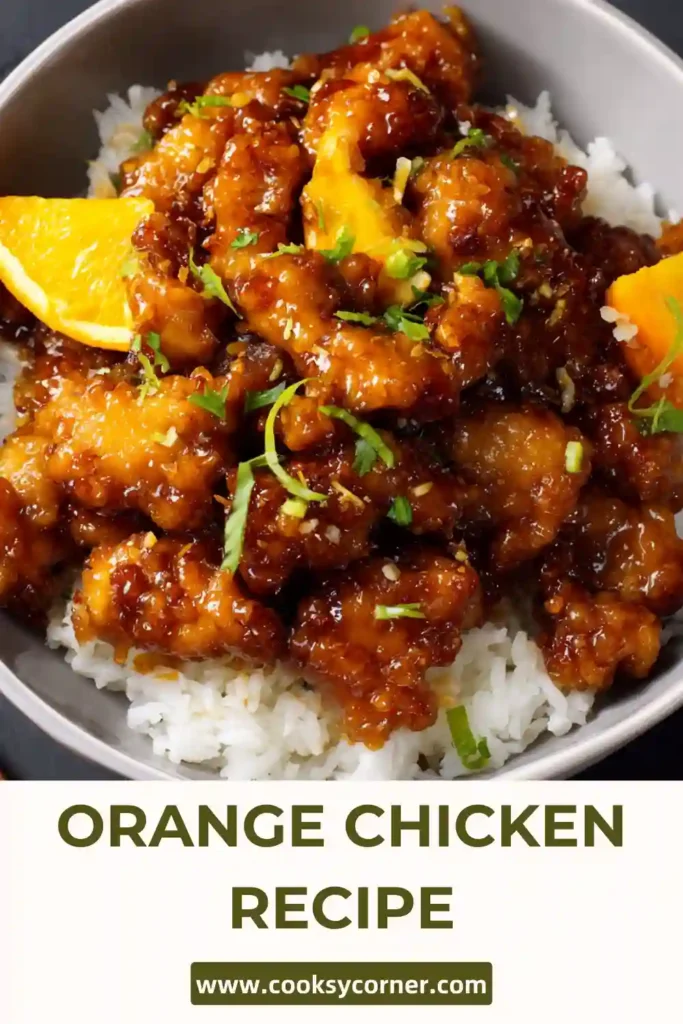 Freshly cooked orange chicken in a pan with vibrant sauce and steam rising.