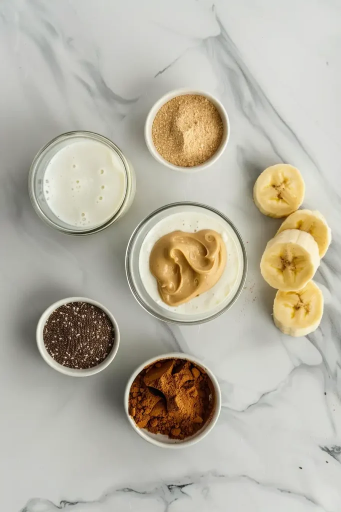 Fresh peanut butter banana smoothie with a swirl of peanut butter and sprinkled cinnamon on top.