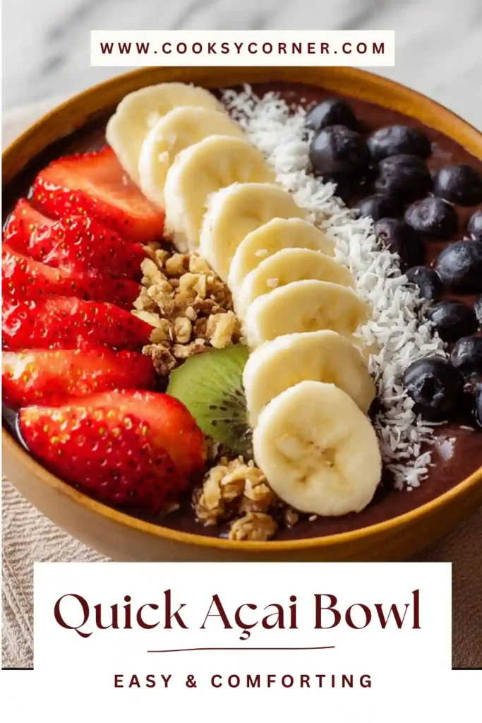 A vibrant quick açai bowl recipe topped with sliced banana, strawberries, blueberries, and crunchy granola in a white bowl.