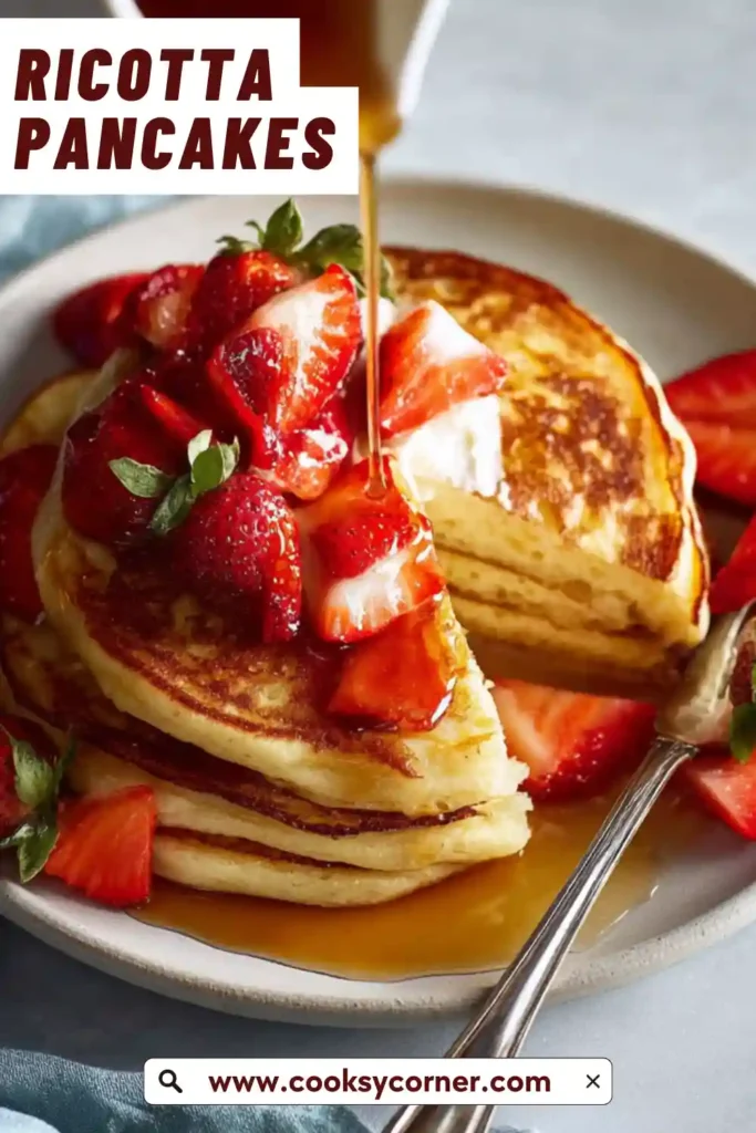 Close-up of ricotta pancakes showing soft interior and golden crust topped with fresh fruit.