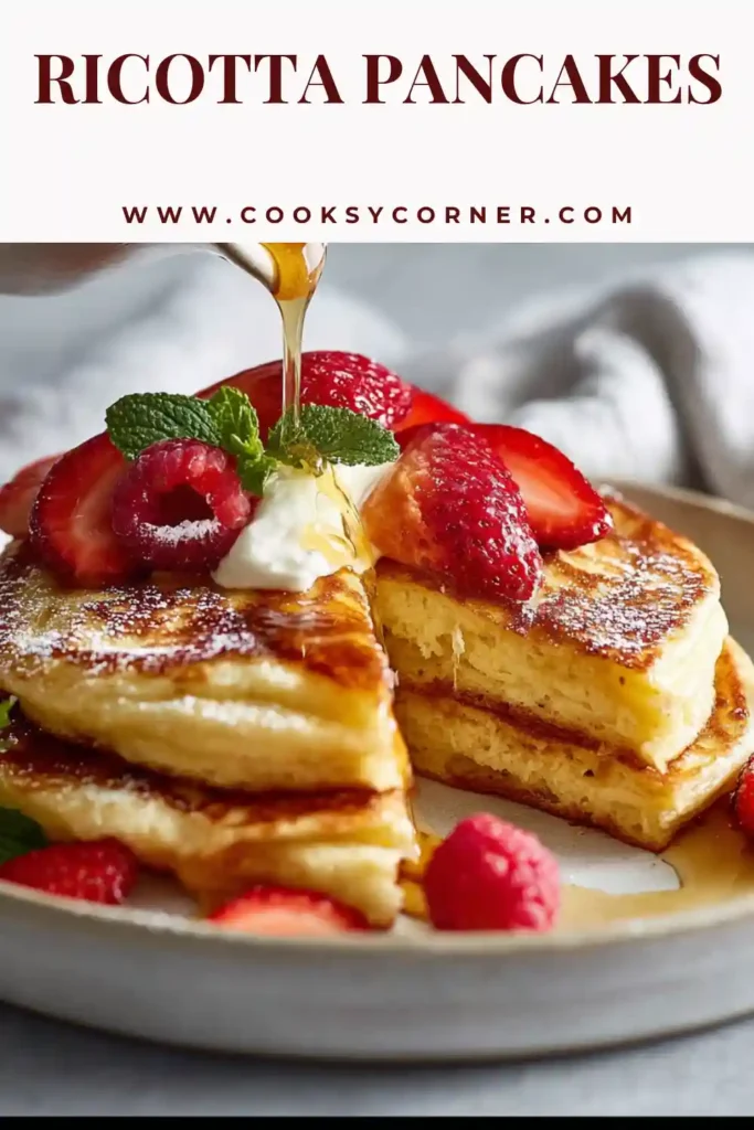 Fluffy ricotta pancakes stacked with fresh strawberries and maple syrup on top. Soft golden pancakes perfect for breakfast.