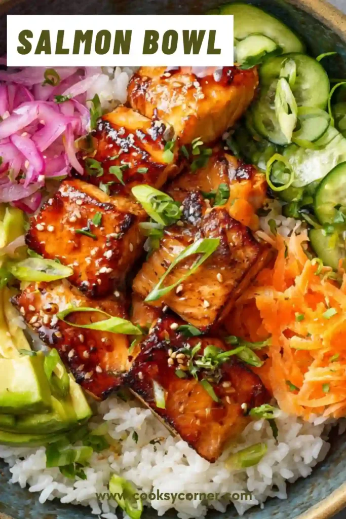 Salmon bowl with rice, avocado, cucumber, and carrots topped with glazed salmon cubes.