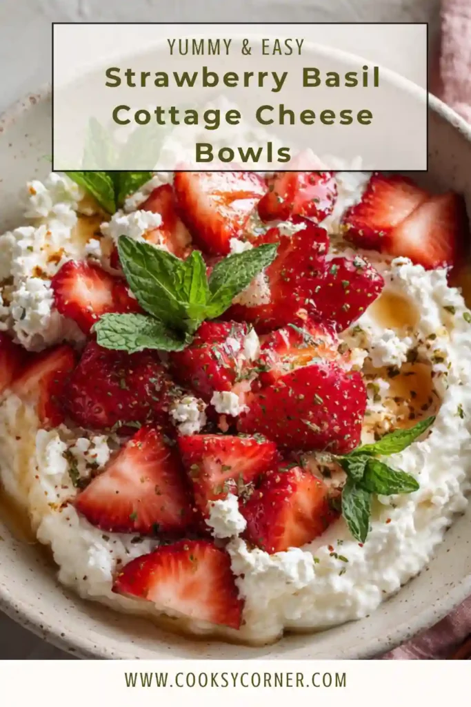 A bowl of cottage cheese topped with fresh strawberries, basil leaves, and chopped pistachios in natural light. This healthy strawberry basil cottage cheese bowl looks fresh and vibrant.