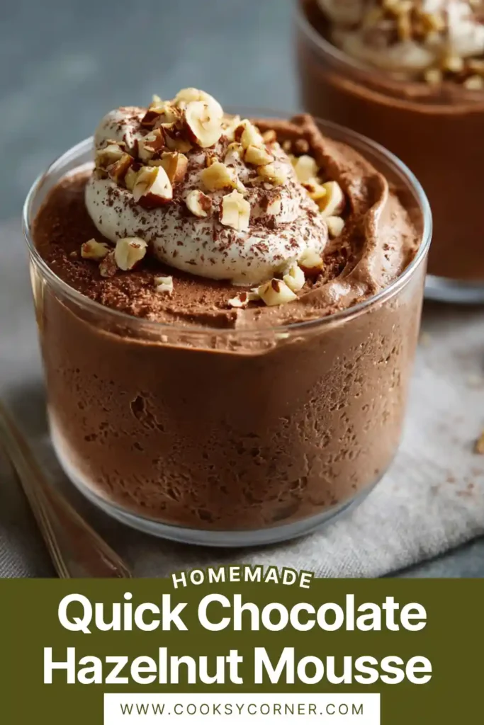 A glass of creamy chocolate hazelnut mousse topped with whipped cream and chopped hazelnuts. The texture looks smooth and airy.