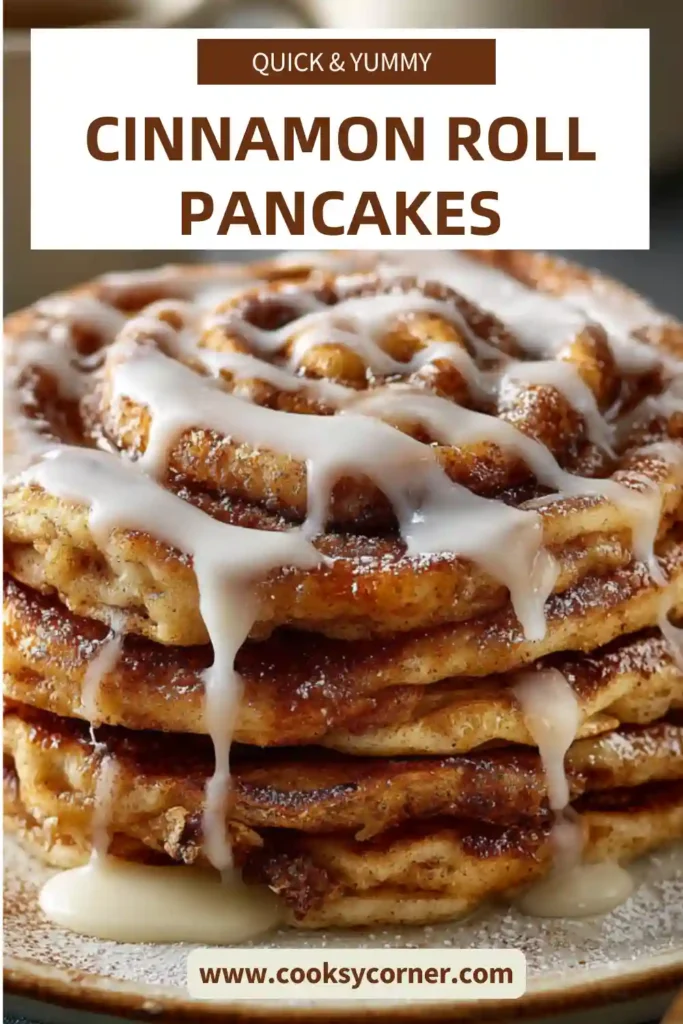 A stack of fluffy Cinnamon Roll Pancakes drizzled with cream cheese glaze and topped with buttery cinnamon swirls. The pancakes are golden brown and served warm for a cozy breakfast.