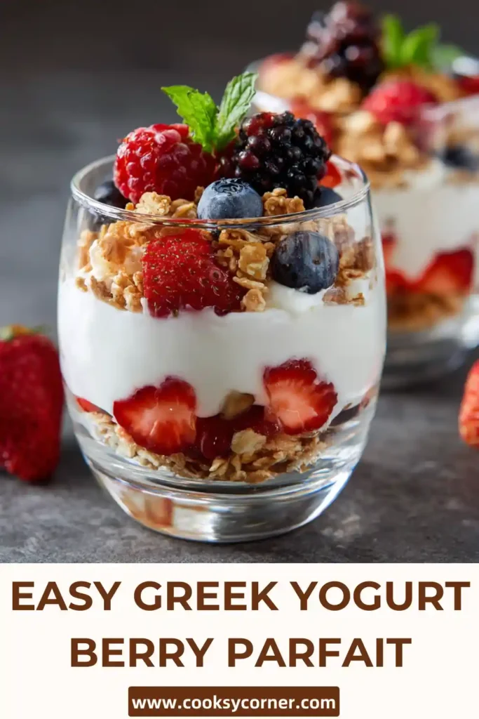 A layered Greek Yogurt Berry Parfait with fresh strawberries, blueberries, and granola in a clear glass. The creamy yogurt contrasts beautifully with the vibrant berries.