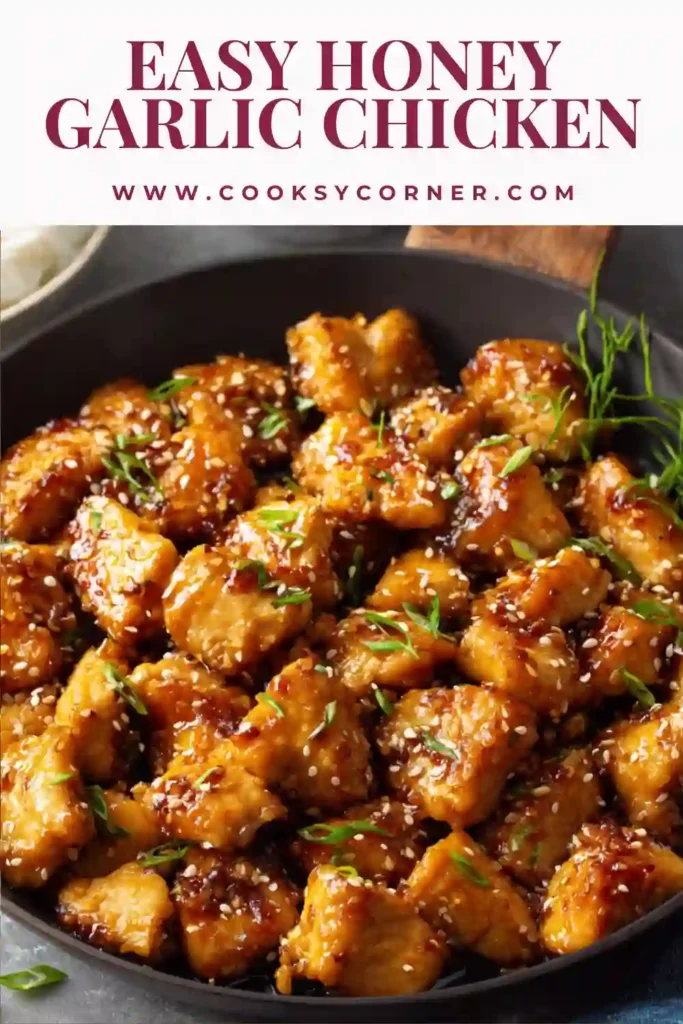 A skillet filled with honey garlic chicken pieces coated in a glossy sauce, garnished with sesame seeds and green onions. The dish looks rich and perfectly cooked for a quick dinner.