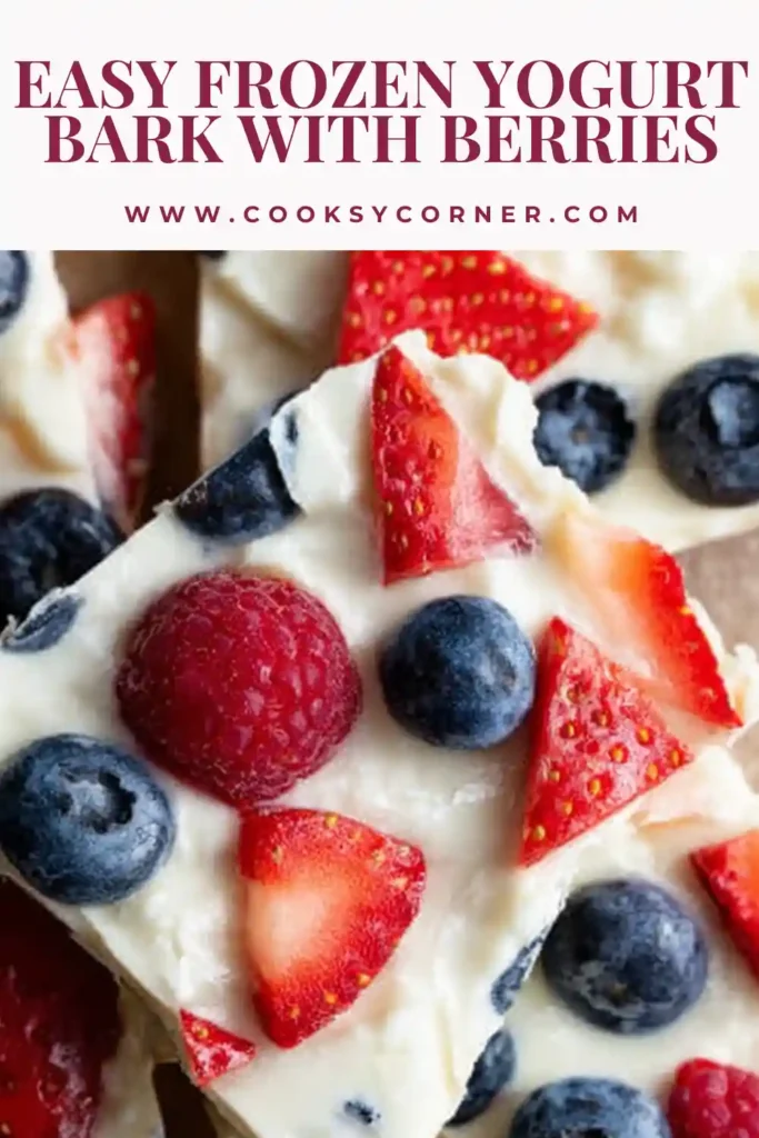 Close-up of frozen yogurt bark pieces with fresh berries and coconut, showing a smooth and slightly icy texture.