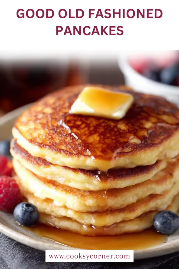 A stack of fluffy Good Old-Fashioned Pancakes topped with butter and maple syrup on a breakfast plate. The homemade pancakes are golden brown, soft, and freshly cooked.