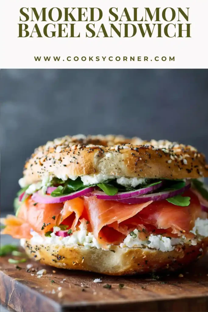 Close-up of a smoked salmon breakfast sandwich with fresh greens and pickled onions.
